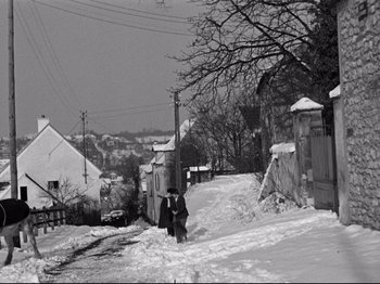 Movie still from “The Silence of the Sea” (1949), directed by Jean-Pierre Melville – A man walking down a snow covered street; Extreme Wide shot, High angle
