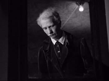 Movie still from “The Silence of the Sea” (1949), directed by Jean-Pierre Melville – A black and white photo of a man looking at himself in the mirror; Close Up shot, Low angle