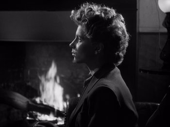 Movie still from “The Silence of the Sea” (1949), directed by Jean-Pierre Melville – A woman in front of a fireplace looking to the side; Close Up shot, Over the shoulder angle