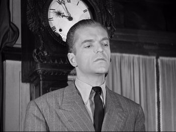Movie still from “The Silence of the Sea” (1949), directed by Jean-Pierre Melville – A man wearing a suit and tie in front of a clock; Close Up shot, Low angle