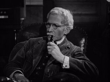 Movie still from “The Silence of the Sea” (1949), directed by Jean-Pierre Melville – An older man sitting in a chair smoking a pipe; Close Up shot, High angle