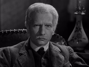 Movie still from “The Silence of the Sea” (1949), directed by Jean-Pierre Melville – An older man with a mustache wearing a suit and tie; Close Up shot, High angle