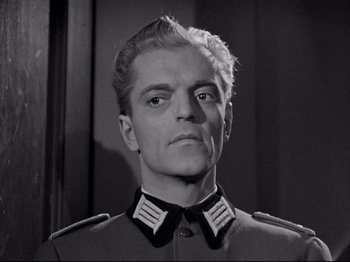 Movie still from “The Silence of the Sea” (1949), directed by Jean-Pierre Melville – A black and white photo of a man in a military uniform; Close Up shot, Low angle