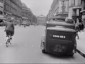 Movie still from “The Silence of the Sea” (1949), directed by Jean-Pierre Melville – An old photo of a street with cars and buildings; Extreme Wide shot, High angle