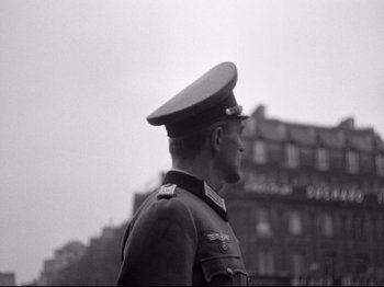 Movie still from “The Silence of the Sea” (1949), directed by Jean-Pierre Melville – A black and white photo of a man in a military uniform; Medium shot, Low angle