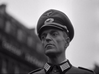 Movie still from “The Silence of the Sea” (1949), directed by Jean-Pierre Melville – A man in a military uniform is looking at the camera; Close Up shot, Low angle