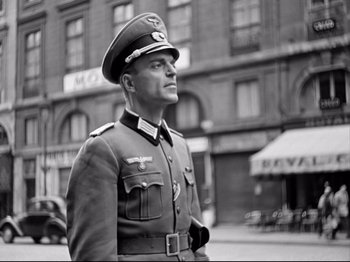 Movie still from “The Silence of the Sea” (1949), directed by Jean-Pierre Melville – An old photo of a man in a military uniform; Medium shot, Low angle