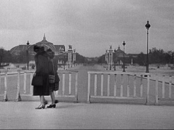 Movie still from “The Silence of the Sea” (1949), directed by Jean-Pierre Melville – Two women walking on a bridge with an open umbrella; Extreme Wide shot, High angle