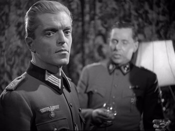 Movie still from “The Silence of the Sea” (1949), directed by Jean-Pierre Melville – A man in a military uniform standing next to another man in a military uniform; Close Up shot, Over the shoulder angle