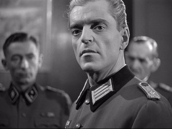 Movie still from “The Silence of the Sea” (1949), directed by Jean-Pierre Melville – A black and white photo of a man in a military uniform; Close Up shot, Over the shoulder angle