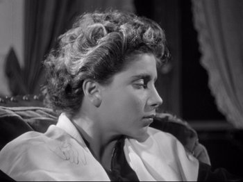 Movie still from “The Silence of the Sea” (1949), directed by Jean-Pierre Melville – A young woman sitting in a chair with her head resting on her arm; Close Up shot, High angle