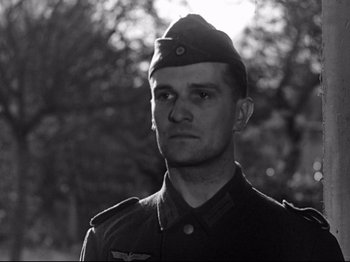 Movie still from “The Silence of the Sea” (1949), directed by Jean-Pierre Melville – Black and white photograph of a man in a military uniform; Close Up shot, Low angle