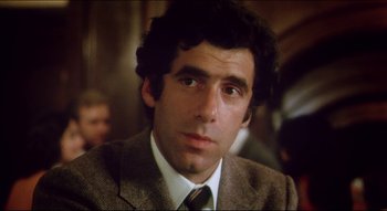 Movie still from “The Silent Partner” (1978), directed by Daryl Duke – A person wearing a suit and tie; Close Up shot, Low angle