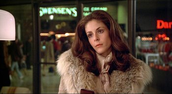 Movie still from “The Silent Partner” (1978), directed by Daryl Duke – A woman in a white fur coat standing in front of a store window; Close Up shot, Low angle