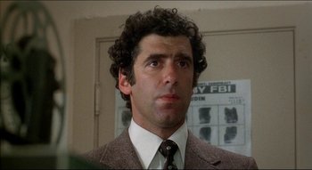 Movie still from “The Silent Partner” (1978), directed by Daryl Duke – A man in a suit and tie in a room; Close Up shot, Low angle