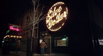 Movie still from “The Silent Partner” (1978), directed by Daryl Duke – A man standing outside of a silver dollar restaurant; Wide shot, Low angle