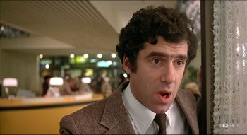 Movie still from “The Silent Partner” (1978), directed by Daryl Duke – A person wearing a suit and tie; Close Up shot, Low angle