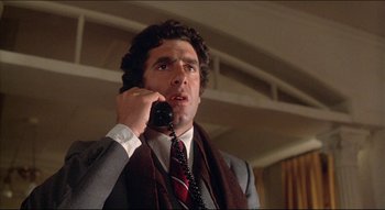 Movie still from “The Silent Partner” (1978), directed by Daryl Duke – A man talking on a phone while wearing a suit and tie; Close Up shot, Low angle