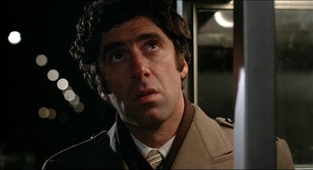 Movie still from “The Silent Partner” (1978), directed by Daryl Duke – A person wearing a suit and tie; Close Up shot, Low angle