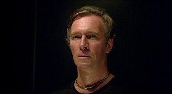 Movie still from “The Silent Partner” (1978), directed by Daryl Duke – A person wearing a black shirt; Close Up shot, Low angle