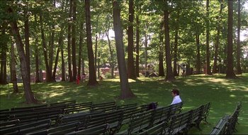 Movie still from “The Silent Partner” (1978), directed by Daryl Duke – A person sitting on a park bench in a park; Extreme Wide shot, High angle