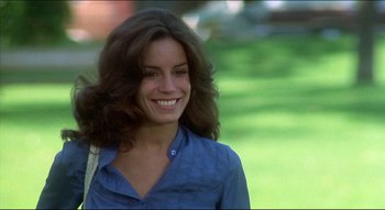 Movie still from “The Silent Partner” (1978), directed by Daryl Duke – A woman with long brown hair smiling for the camera; Close Up shot, Over the shoulder angle