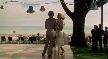 Movie still from “The Silent Partner” (1978), directed by Daryl Duke – A man and a woman are dancing on the sidewalk; Wide shot, Low angle