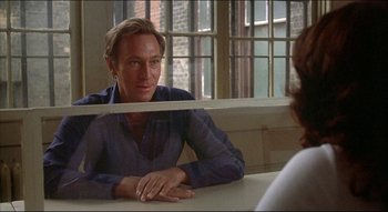 Movie still from “The Silent Partner” (1978), directed by Daryl Duke – A man sitting at a table in front of a mirror; Close Up shot, Over the shoulder angle