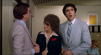 Movie still from “The Silent Partner” (1978), directed by Daryl Duke – A group of people standing next to each other in a room; Medium shot, Low angle