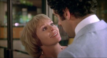 Movie still from “The Silent Partner” (1978), directed by Daryl Duke – A man and a woman smiling at each other; Close Up shot, Over the shoulder angle