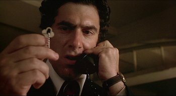 Movie still from “The Silent Partner” (1978), directed by Daryl Duke – A person talking on a phone; Close Up shot, Low angle