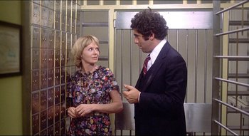 Movie still from “The Silent Partner” (1978), directed by Daryl Duke – A man and a woman standing next to each other; Medium shot, Low angle