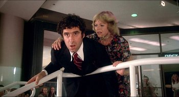Movie still from “The Silent Partner” (1978), directed by Daryl Duke – A man and a woman standing next to a railing; Medium shot, Low angle