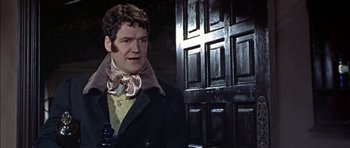 Movie still from “The Skull” (1965), directed by Freddie Francis – A person standing near a door; Medium shot, Over the shoulder angle