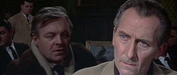 Movie still from “The Skull” (1965), directed by Freddie Francis – A man in a suit and tie next to another man in a suit and tie; Close Up shot, Over the shoulder angle