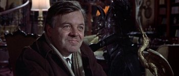 Movie still from “The Skull” (1965), directed by Freddie Francis – An older man wearing a brown coat and a white tie; Close Up shot, Over the shoulder angle