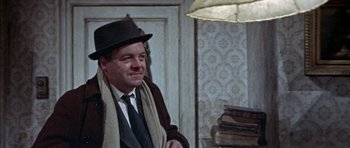 Movie still from “The Skull” (1965), directed by Freddie Francis – A man wearing a hat and a tie; Medium shot, High angle