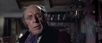 Movie still from “The Skull” (1965), directed by Freddie Francis – An old man with glasses and a purple shirt; Close Up shot, Low angle