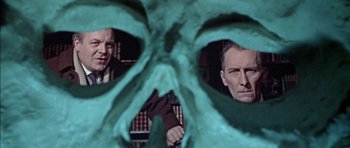 Movie still from “The Skull” (1965), directed by Freddie Francis – Two men looking at each other through a fake skull; Close Up shot, Low angle