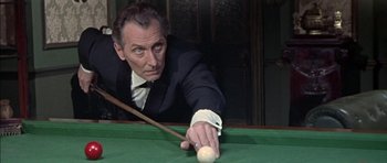 Movie still from “The Skull” (1965), directed by Freddie Francis – An older man in a suit and tie playing pool; Close Up shot, High angle