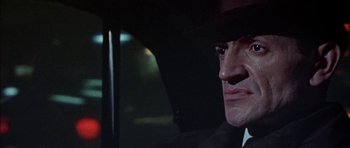 Movie still from “The Skull” (1965), directed by Freddie Francis – A person wearing a hat in a car; Close Up shot, Low angle