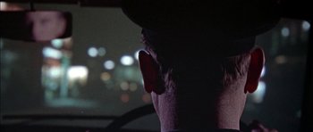 Movie still from “The Skull” (1965), directed by Freddie Francis – A man with his head turned to the side; Close Up shot, Over the shoulder angle