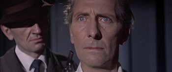 Movie still from “The Skull” (1965), directed by Freddie Francis – An older man with blue eyes looking at the camera; Close Up shot, Over the shoulder angle