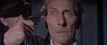 Movie still from “The Skull” (1965), directed by Freddie Francis – A person holding a gun up to their head; Close Up shot, High angle