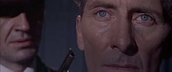 Movie still from “The Skull” (1965), directed by Freddie Francis – A man's face with a gun in his hand; Extreme Close Up shot, High angle
