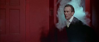 Movie still from “The Skull” (1965), directed by Freddie Francis – A man standing in front of a wall with steam coming out of it; Medium shot, Low angle