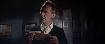 Movie still from “The Skull” (1965), directed by Freddie Francis – A man holding an envelope in his hands; Close Up shot, Low angle