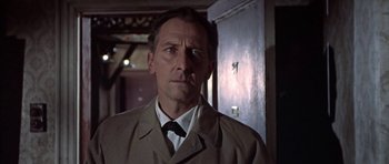 Movie still from “The Skull” (1965), directed by Freddie Francis – A person wearing a suit and tie; Close Up shot, Low angle