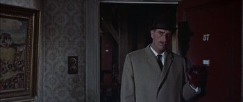 Movie still from “The Skull” (1965), directed by Freddie Francis – A man in a suit and hat standing in a doorway; Close Up shot, Low angle