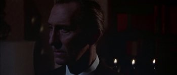 Movie still from “The Skull” (1965), directed by Freddie Francis – A person wearing a suit and tie; Close Up shot, Low angle